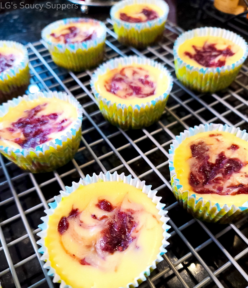 Individual strawberry cheesecakes on cooling rack